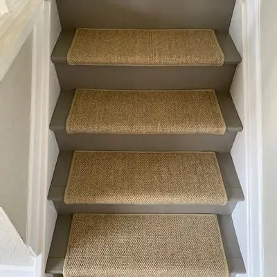 Beige herringbone carpet treads on gray painted stairs