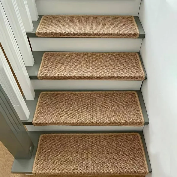 Four grey wooden stairs with rectangular natural jute tread rugs.