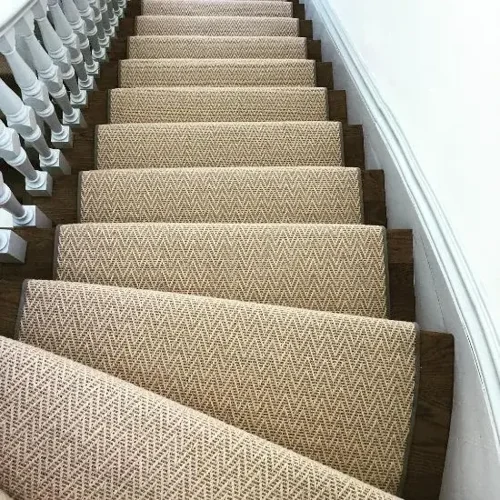 Herringbone sisal stair runner with black borders on white and black stairs in a Dubai home.