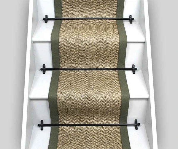 Sisal stair runner with green borders and black rods.