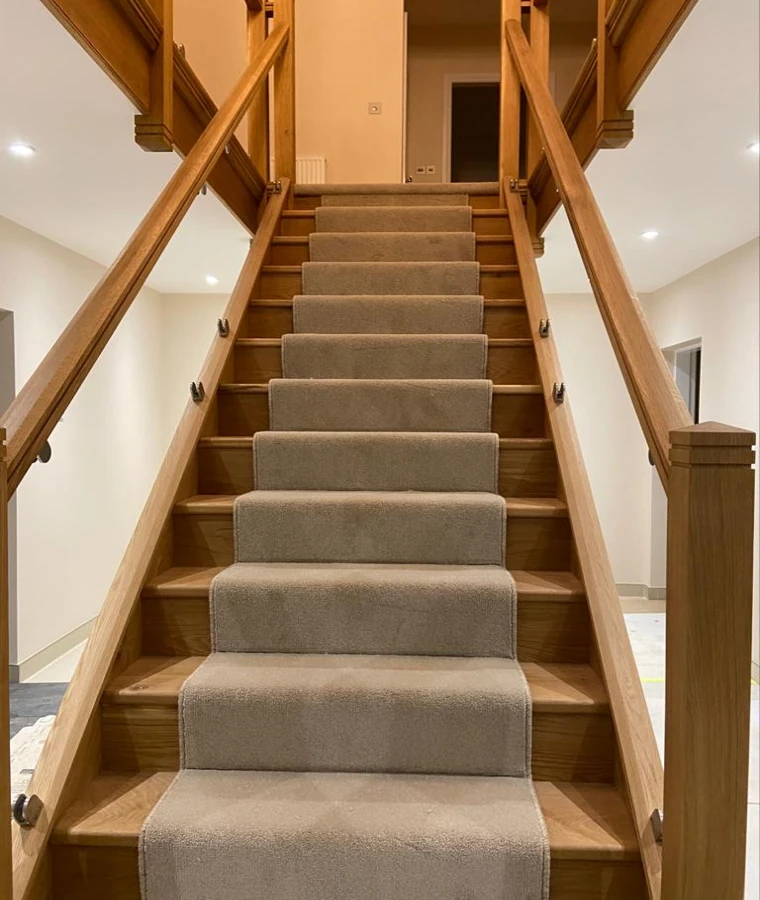 Wool stair carpet runner on a wooden staircase with handrails