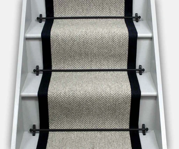 neutral beige herringbone sisal carpet runner on white wooden stairs.