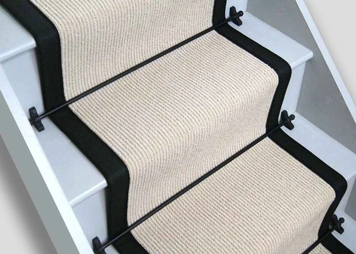 wool stair runner with a textured, ribbed weave and a wide black fabric border on white-painted wooden stairs.