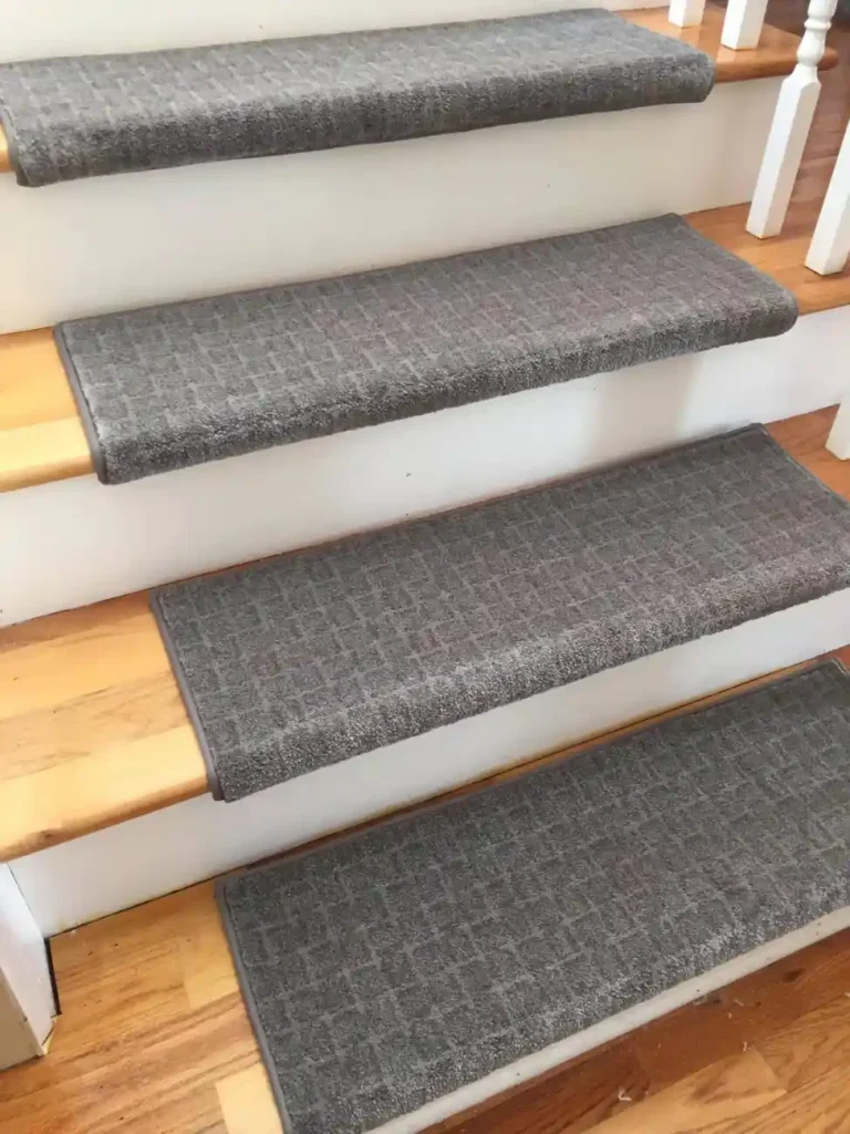 Grey speckled shag carpet stair treads on light wood steps