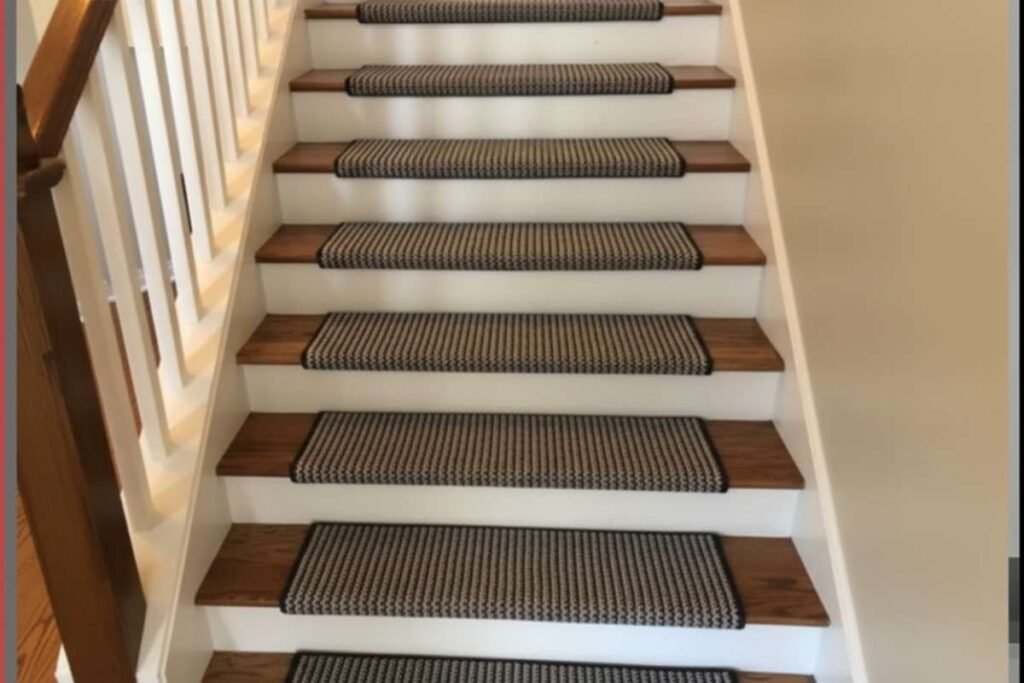 Wooden stairs with white risers, featuring decorative black and beige patterned non-slip carpet treads on each step.