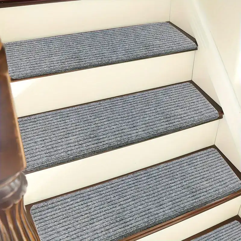 Gray carpet treads on light wood stairs with dark spindles